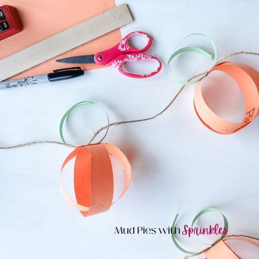 The tools and materials for making a thankful pumpkin craft garland for kids including sharpie, ruler, stapler, twine, scissors, and construction paper.